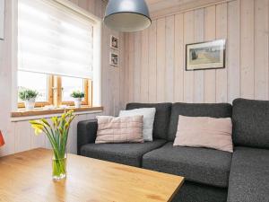 a living room with a couch and a table at 2 person holiday home in Otterup in Otterup +14 photos