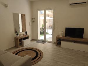 a living room with a flat screen tv and a couch at Corte Antica Marsala in Marsala