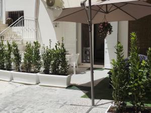a patio with an umbrella and potted plants at Corte Antica Marsala in Marsala