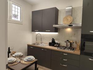 a kitchen with a sink and a stove top oven at Corte Antica Marsala in Marsala
