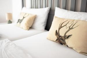 托特莫斯Ferienwohnung Panoramablick - super für deine Familie und die besten Aussicht in ganz Todtmoos的床上有枕头,上面有鹿头