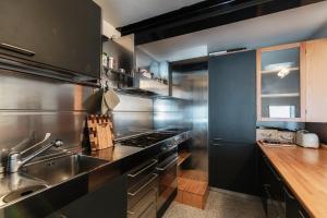 a kitchen with stainless steel appliances and a sink at Grace Suite with Jacuzzi Wonderful Lakefront View in Colonno