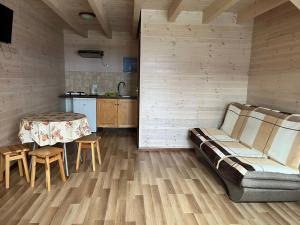 una sala de estar con un sofá y una mesa en Domki Vesper Międzywodzie, en Międzywodzie
