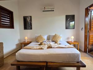 a bed in a room with two tables and two lamps at Azul Flats in Jericoacoara