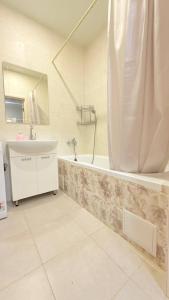 a bathroom with a tub and a sink and a shower at Студио Район-2 in Kyiv