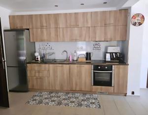 a kitchen with wooden cabinets and a refrigerator at Къща за гости Вила Чифлици in Chiflik
