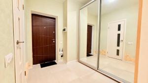 a bathroom with a large mirror and a door at Студио Район-2 in Kyiv +8 photos