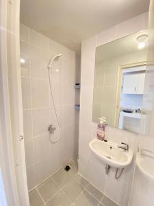 a white bathroom with a sink and a shower at Tokyo River side PIK2 By Micky Studio 5 in Muara