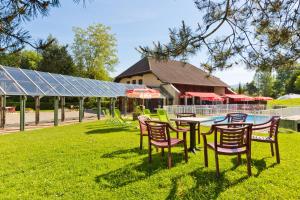 een groep stoelen en een tafel in het gras bij Logis Albhotel Grill in Alby