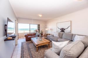 a living room with a couch and a table at Panoramic Ocean View 2 bed w 24 hour Power Inverter, Blouberg, 28 Malata in Bloubergstrand