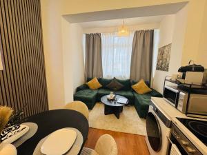 un salon avec un canapé vert et une table dans l'établissement 3-Raum-City-Apartment Ost-5, à Düsseldorf