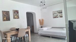a small room with a bed and a table and chairs at SunWaves Apartments in Keramoti