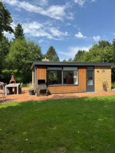 a contemporary extension to a house with a lawn at Bungalow De Hazelaar I 4 personen - Vakantiepark De Kremmer in Gasselte