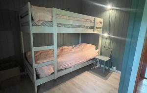 a bedroom with two bunk beds and a table at Holmsjøhytta in Sjørbotn