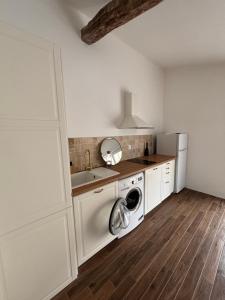 a kitchen with a washing machine and a sink at Studio proche de Jonzac in La Celle-sous-Gouzon