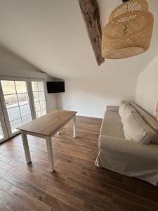 a living room with a table and a couch at Studio proche de Jonzac in La Celle-sous-Gouzon
