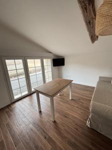 a wooden table in a living room with a couch at Studio proche de Jonzac in La Celle-sous-Gouzon