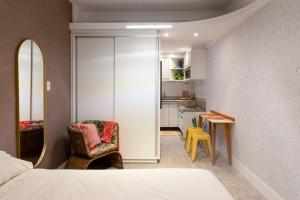 a bedroom with a bed and a chair and a table at Studio XV Centro Florianópolis Centro Sul Eventos in Florianópolis