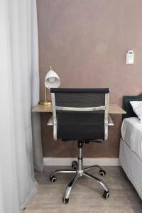 a bedroom with a desk and a chair next to a bed at Studio XV Centro Florianópolis Centro Sul Eventos in Florianópolis