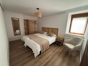 a bedroom with a large bed and a chair at El Refugio de los Corrales in San Mateo