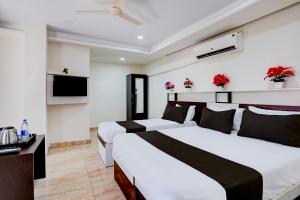a hotel room with two beds and a television at Super Hotel O SGR Palace in Bengaluru