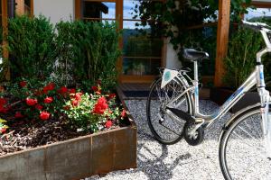 una bicicletta parcheggiata di fronte a un giardino fiorito di Apartments Mitterhof 1544 a Brunico