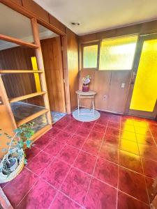 a room with a red tile floor and a table at Casa Cypresses in Temuco