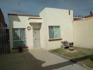 a white house with two windows and a gate at Casa confortable in Silao