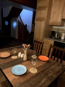 a wooden table with plates and wine glasses on it at Ferienhaus Brigitte in Schönecken