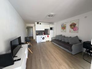 Una sala de estar con un sofá y una cocina. en Casa Giorì playa de las Americas, en Playa de las Américas