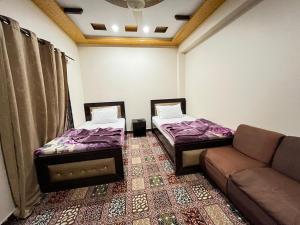 a living room with two beds and a couch at Indus Hotel Quetta in Kachāhri