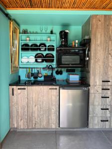 a kitchen with a stove and a microwave at Garden Studio -Designed for rest, built for two in Kourouta
