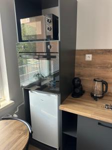 a kitchen with a refrigerator and a microwave at Apartmánový byt Bakossova in Banská Bystrica