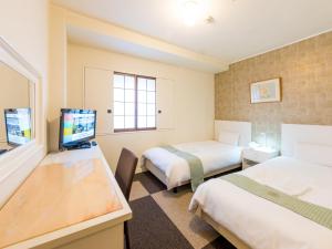 a hotel room with two beds and a desk at New Osaka Hotel in Osaka +24 photos