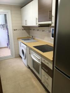 a kitchen with a washer and a sink and a dishwasher at Casa Candelaria in Benidorm