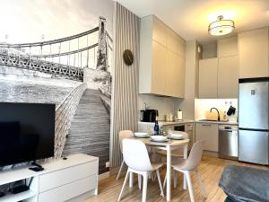 a kitchen with a dining table with a wall mural of a bridge at Michalczyka 3A - Self Check-In 20h - Parking in Wrocław