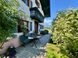 a bench sitting outside of a building with a balcony at TONIS cozy Boutique Chalet by ALPIN CHARME APARTMENTS in Reith bei Kitzbühel