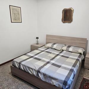 a bedroom with a bed with a checkered blanket at Villetta dei pini in Canzo +11 photos