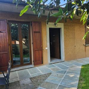 a house with two wooden doors and a patio at Villetta dei pini in Canzo