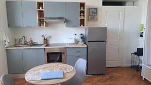 a small kitchen with a table and a refrigerator at Chez Nous in Saint-Paul-lès-Dax