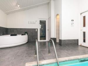 a large bathroom with a tub and a bath tub at Luxury Retreat with Pool - By Traum Ferienwohnungen in Grønhøj