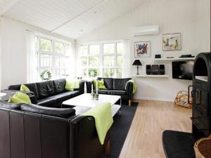 a living room with black leather couches and a table at Luxury Retreat with Pool - By Traum Ferienwohnungen in Grønhøj +18 photos