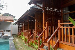 a house with a wooden fence and a swimming pool at Villa Budalipir - Uluwatu Bali in Uluwatu