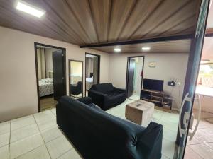 a living room with a couch and a tv at Casa Lumiar DudaBela in Nova Friburgo