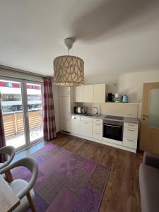 a kitchen with white cabinets and a purple rug at Appartements Luna in Schladming
