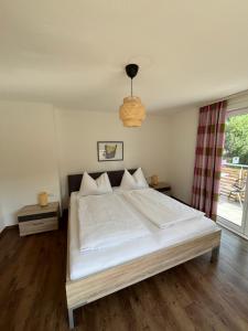 a bedroom with a large white bed and a window at Appartements Luna in Schladming
