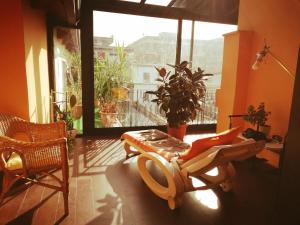 a living room with a large window and a chair at Oasi di Frattamaggiore in Frattamaggiore