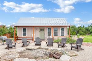 une petite maison avec des chaises et un foyer extérieur dans l'établissement RusTx Ranch Cottage Group 4-6, à Wimberley