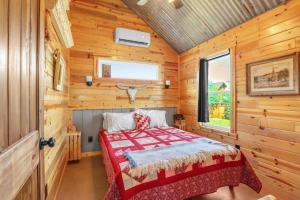 une chambre avec un lit dans une cabane en bois dans l'établissement RusTx Ranch Cottage Group 4-6, à Wimberley