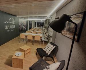a room with a long table and chairs and a lamp at Ski Und Gruppenhaus in Alt Sankt Johann +11 photos
